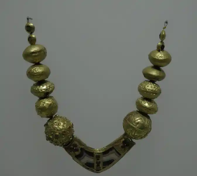 Gold necklace with beads with cross.